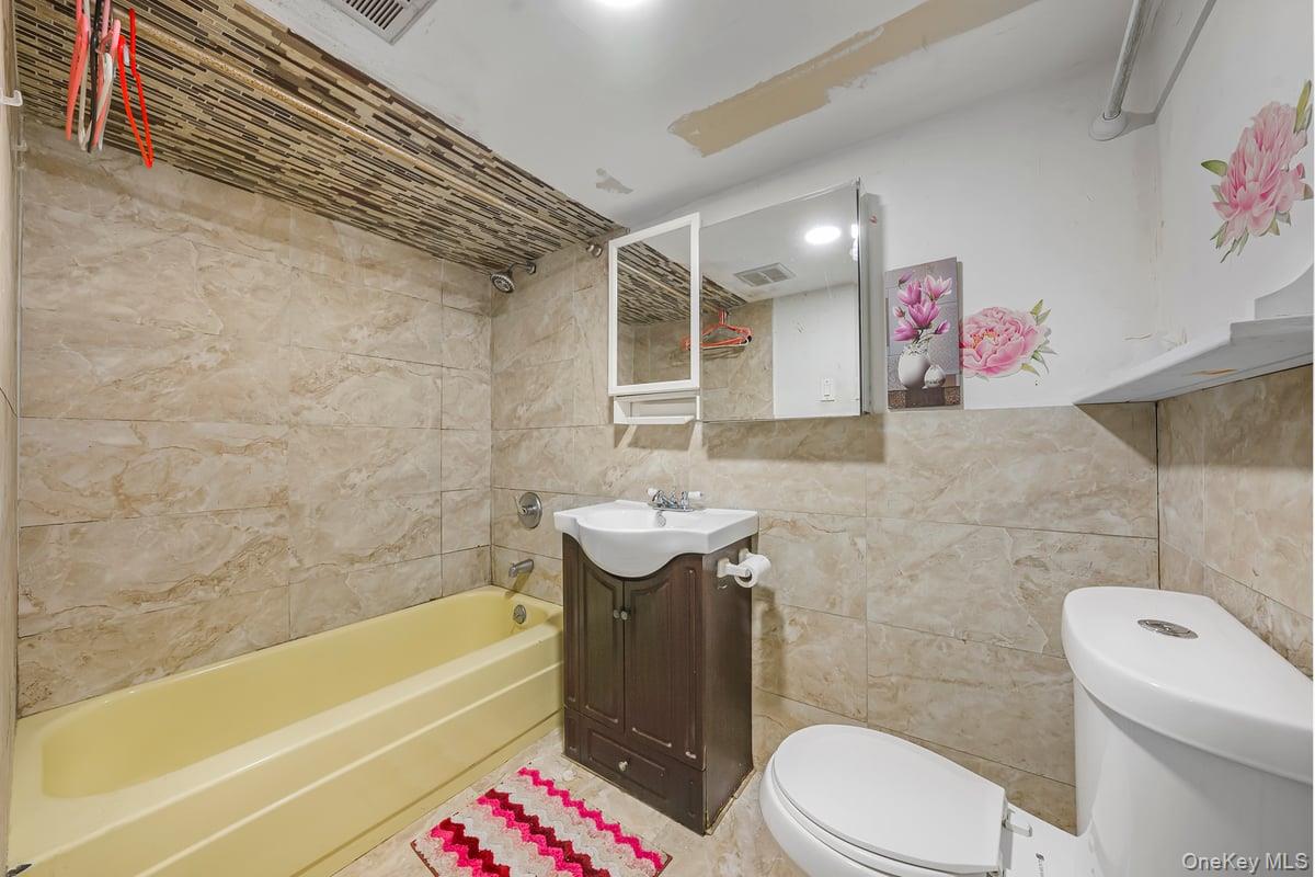 130-24 Springfield Boulevard Queens, NY 11413 - Photo 17 of 20 a bathroom with a sink a toilet and bathtub