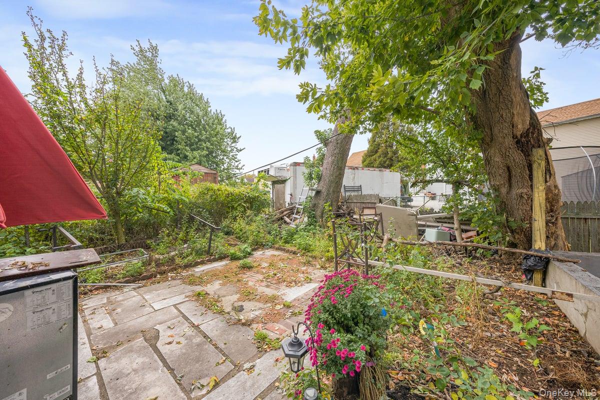 130-24 Springfield Boulevard Queens, NY 11413 - Photo 18 of 20 a view of backyard with a table and chair under an umbrella