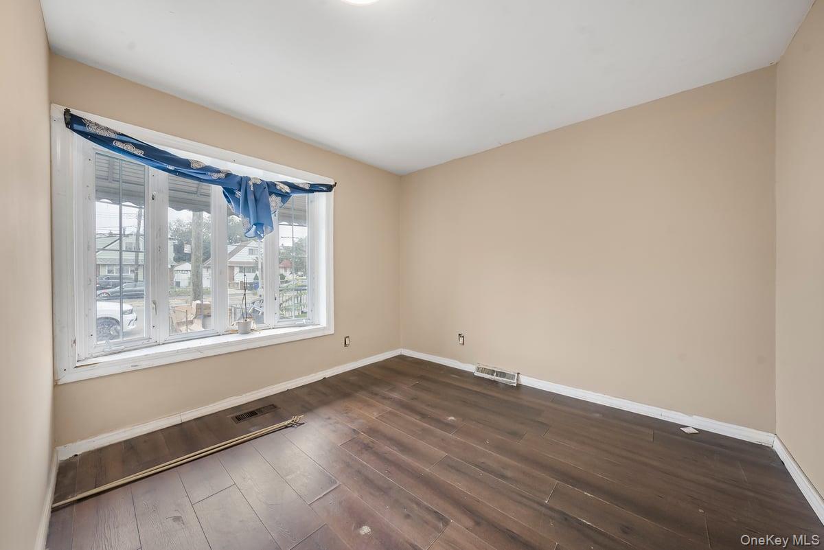 130-24 Springfield Boulevard Queens, NY 11413 - Photo 2 of 20 a view of empty room with wooden floor and fan