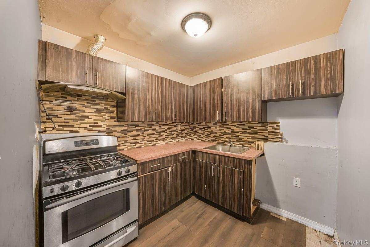 130-24 Springfield Boulevard Queens, NY 11413 - Photo 6 of 20 a kitchen with a stove and a sink