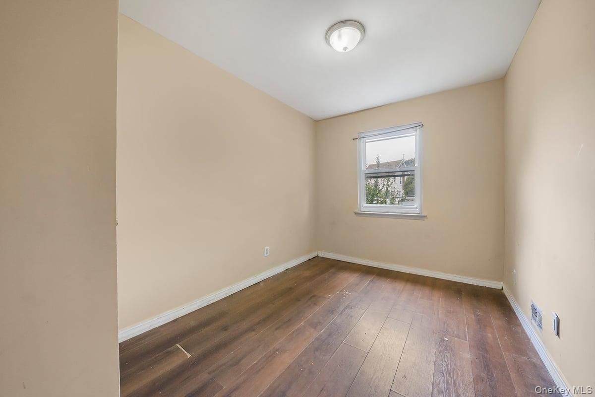 130-24 Springfield Boulevard Queens, NY 11413 - Photo 9 of 20 an empty room with wooden floor and windows