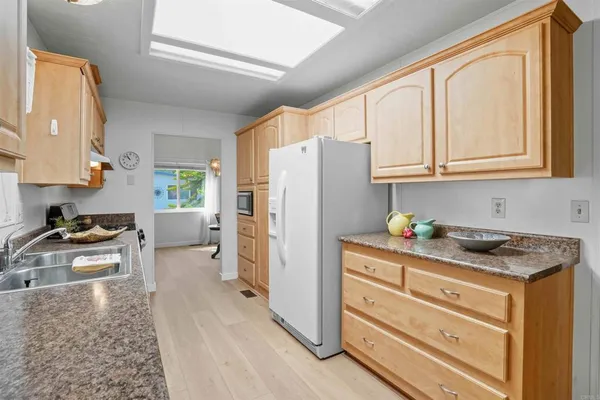 a kitchen with granite countertop a refrigerator stove and sink
