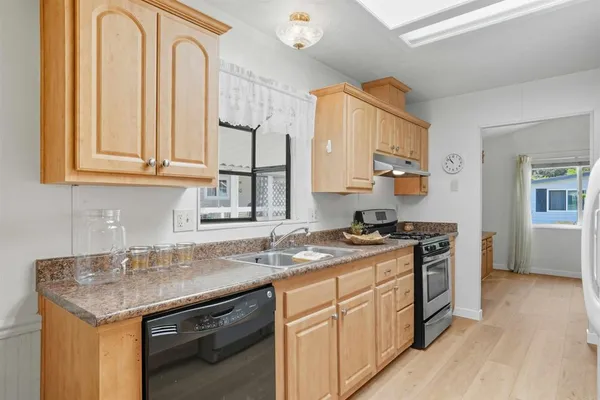 a kitchen with stainless steel appliances granite countertop a sink stove and cabinets