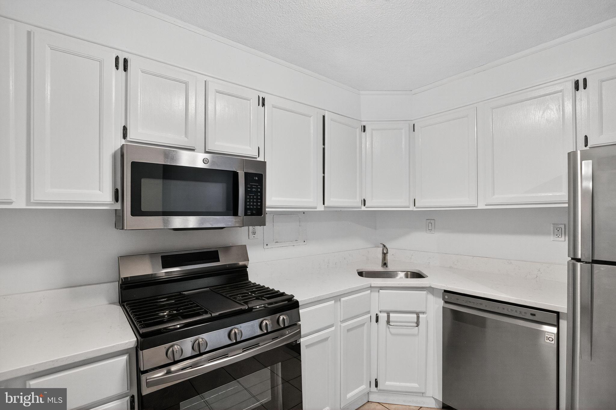 4600 South Four Mile Run Drive, Unit 421 Arlington, VA 22204 - Photo 5 of 17 Modern kitchen with sleek white cabinetry.