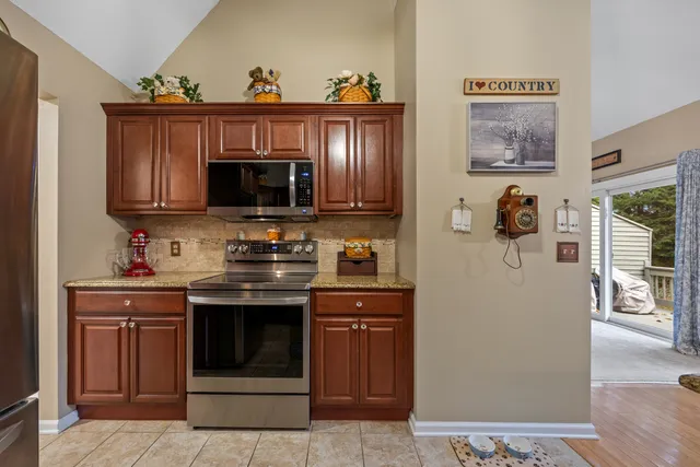 a kitchen with stainless steel appliances granite countertop a stove and a microwave