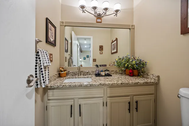 a bathroom with a granite countertop sink a large mirror and vanity
