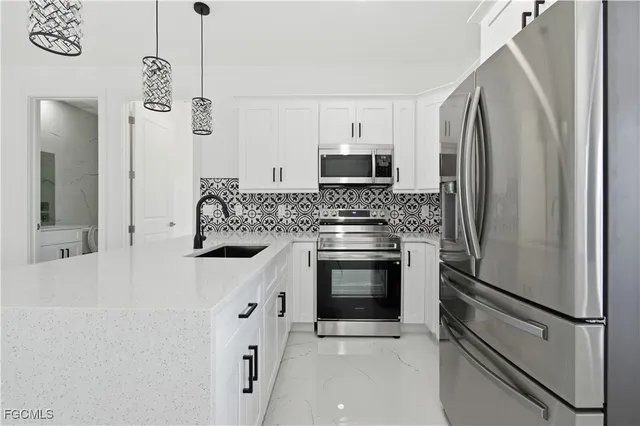 a kitchen with stainless steel appliances a refrigerator sink and microwave