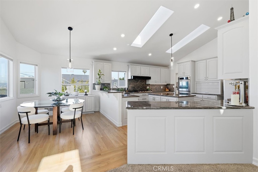 8325 Delgany Avenue Playa del Rey, CA 90293 - Photo 9 of 50 a kitchen with stainless steel appliances kitchen island granite countertop a table chairs and a cabinets