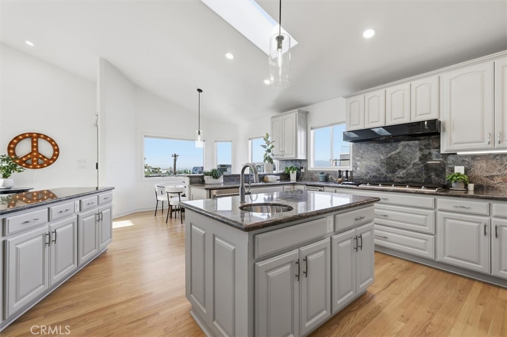 8325 Delgany Avenue Playa del Rey, CA 90293 - Photo 10 of 50 a kitchen with granite countertop a sink stove cabinets and wooden floor