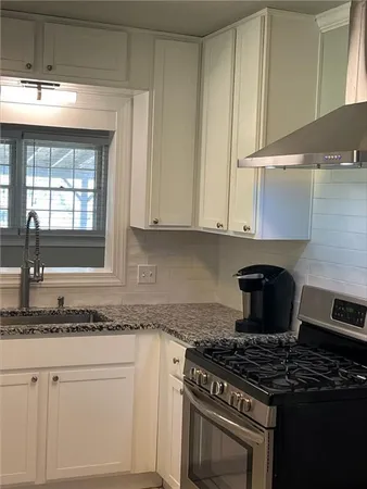 a kitchen with granite countertop a stove and a sink