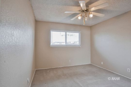 1144 West St George Avenue Ridgecrest, CA 93555 - Photo 15 of 18 an empty room with windows and fan