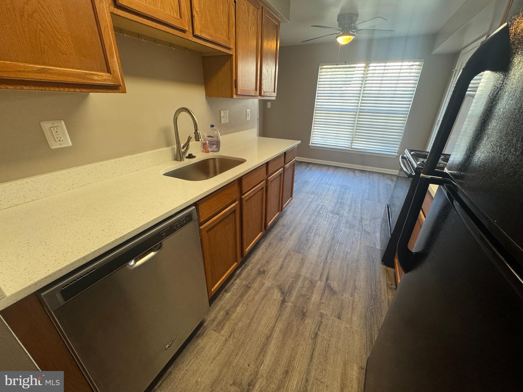 11263 Raging Brook Drive, Unit 253 Bowie, MD 20720 - Photo 12 of 22 a kitchen with kitchen island wooden floors granite top and stainless steel appliances