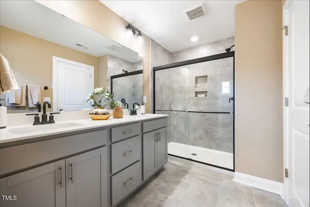 a bathroom with a shower sink and mirror