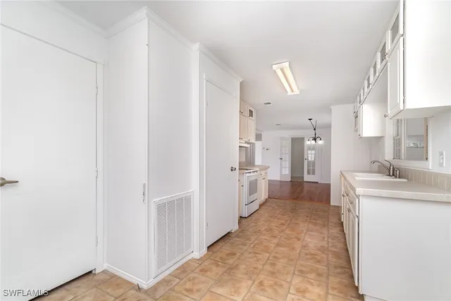 a kitchen with white cabinets and refrigerator