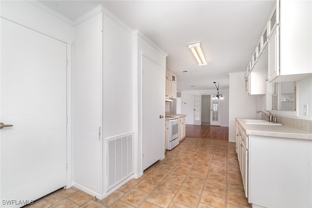 7679 Farrell Road Bokeelia, FL 33922 - Photo 12 of 34 a kitchen with white cabinets and refrigerator