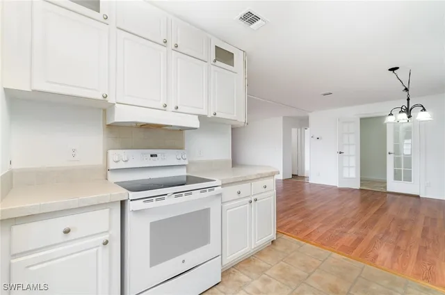 a kitchen with cabinets appliances and wooden floor