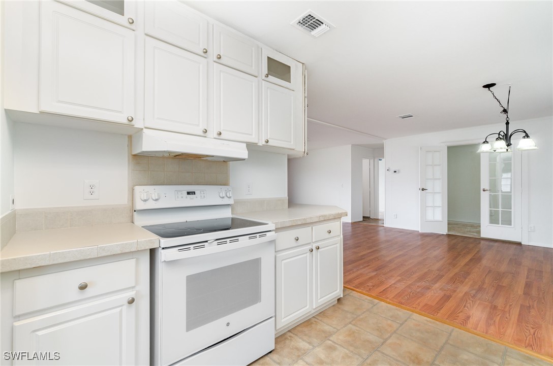 7679 Farrell Road Bokeelia, FL 33922 - Photo 13 of 34 a kitchen with cabinets appliances and wooden floor