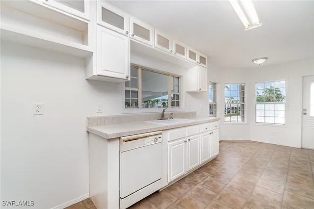 a kitchen with granite countertop white cabinets and white appliances