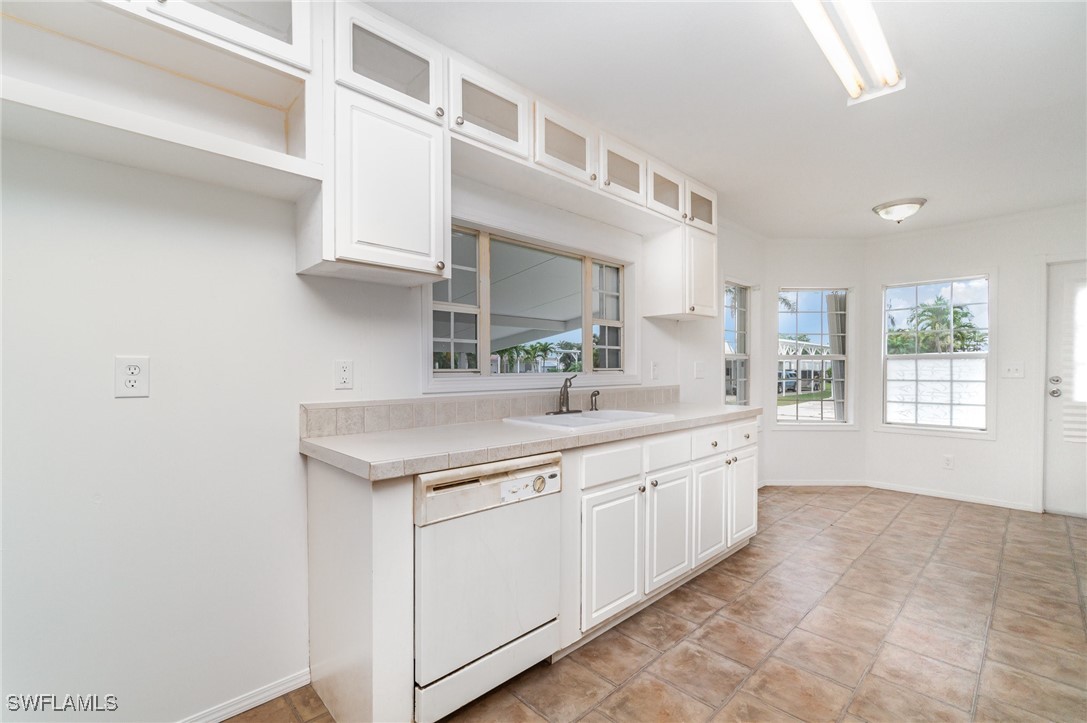 7679 Farrell Road Bokeelia, FL 33922 - Photo 14 of 34 a kitchen with granite countertop white cabinets and white appliances