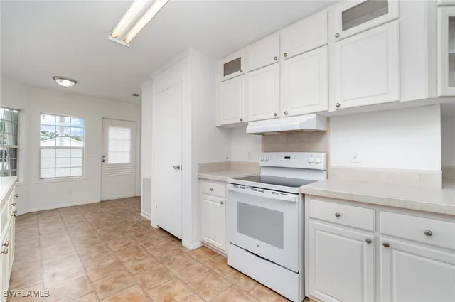 a kitchen with white cabinets and white appliances