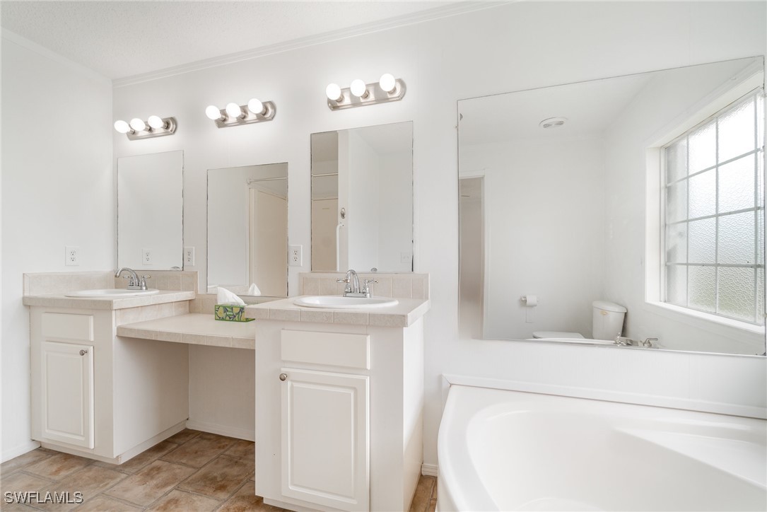 7679 Farrell Road Bokeelia, FL 33922 - Photo 18 of 34 a bathroom with a sink and a mirror