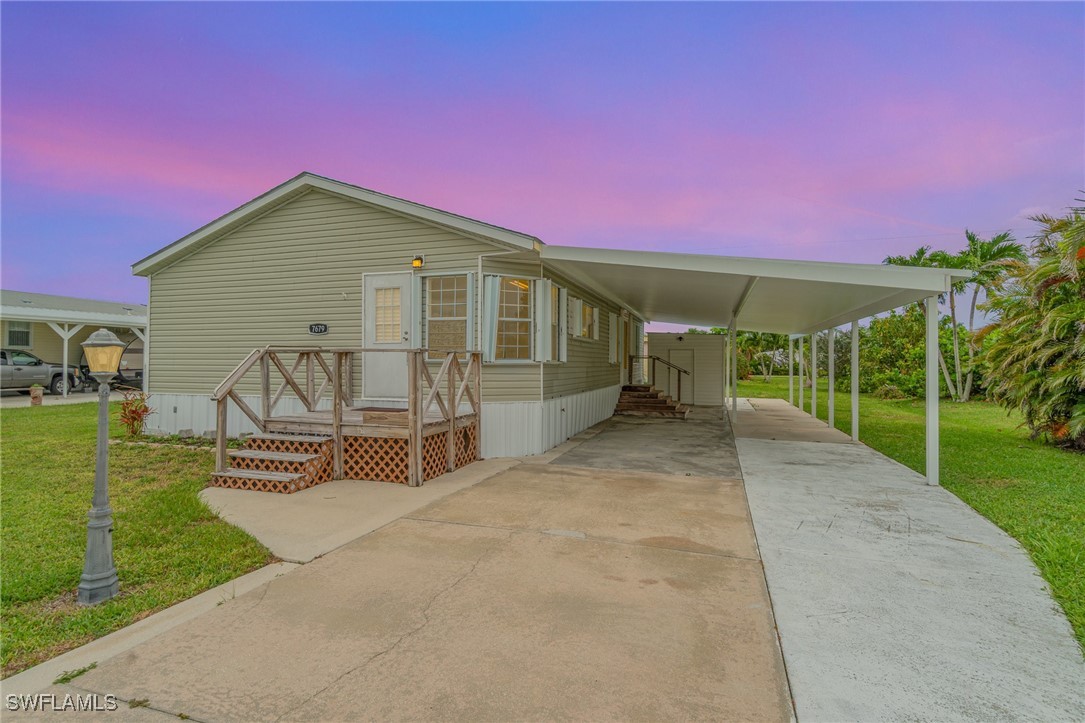 7679 Farrell Road Bokeelia, FL 33922 - Photo 2 of 34 a front view of a house with a yard and entertaining space