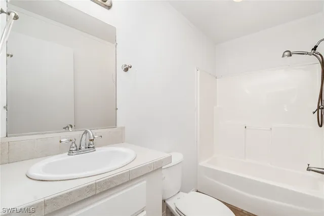 a bathroom with a granite countertop sink toilet and a bathtub