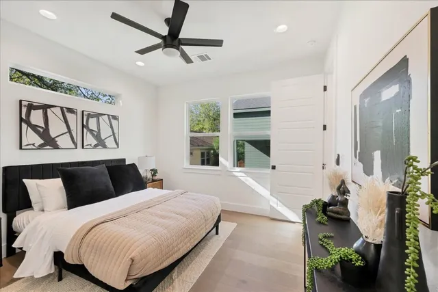 a bedroom with a large bed and a potted plant