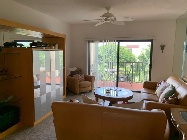 a living room with furniture and a floor to ceiling window
