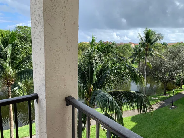 a view of a yard and plant from a balcony