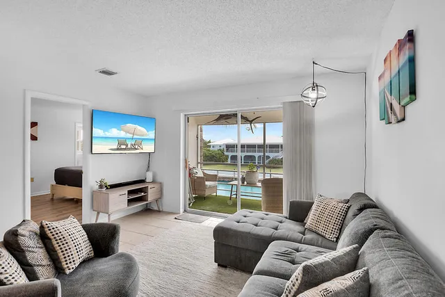 a living room with furniture a large window and a flat screen tv