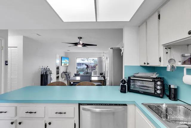 a kitchen with kitchen island a counter top space a sink stainless steel appliances and cabinets