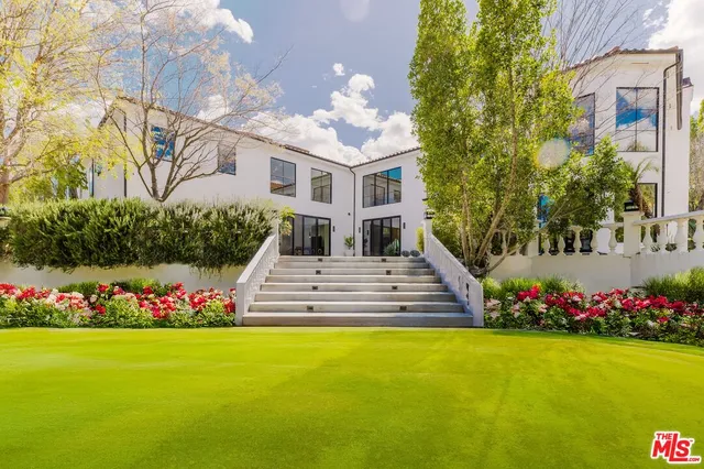 a front view of a house with a yard and fountain