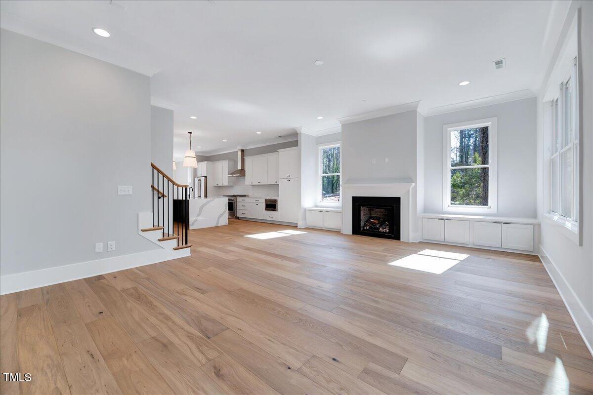 811 Maple Berry Lane, Unit 106 Raleigh, NC 27607 - Photo 6 of 30 an empty room with wooden floor and fireplace