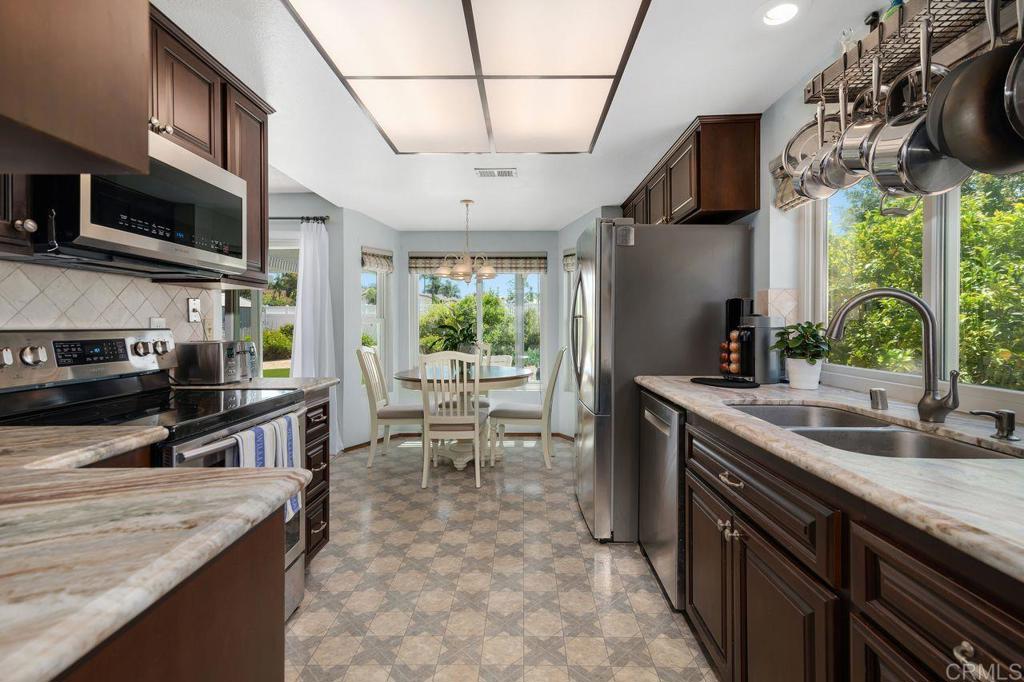 1064 Glen Arbor Drive Encinitas, CA 92024 - Photo 12 of 39 a kitchen with stainless steel appliances granite countertop a sink a stove and a wooden cabinets