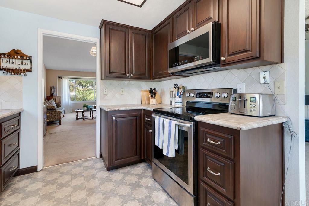 1064 Glen Arbor Drive Encinitas, CA 92024 - Photo 13 of 39 a kitchen with stainless steel appliances granite countertop a stove a microwave and a refrigerator