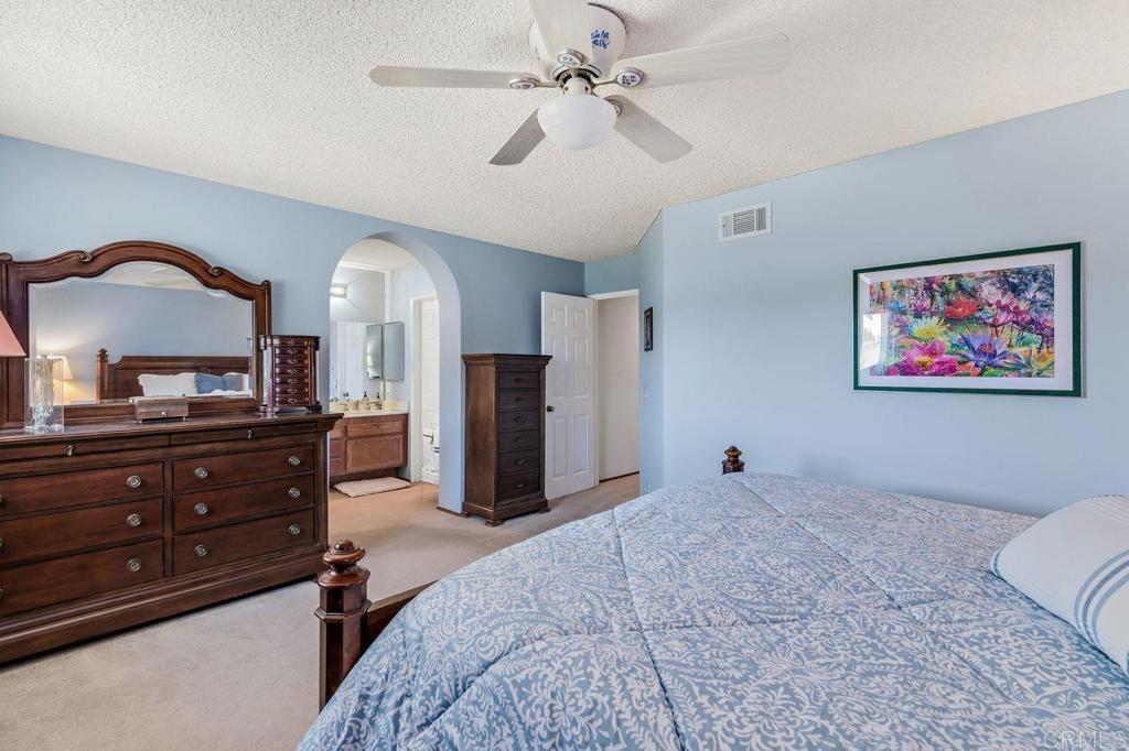 1064 Glen Arbor Drive Encinitas, CA 92024 - Photo 23 of 39 a bedroom with a bed and a chandelier