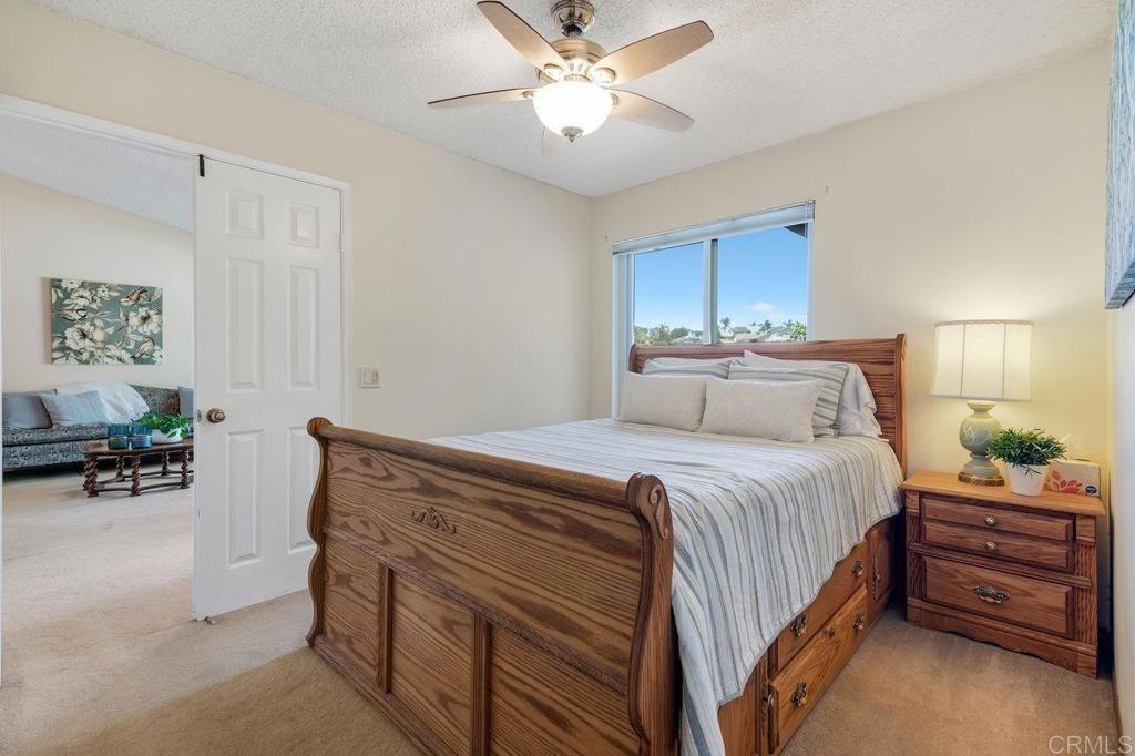 1064 Glen Arbor Drive Encinitas, CA 92024 - Photo 26 of 39 a bedroom with a bed and a chandelier