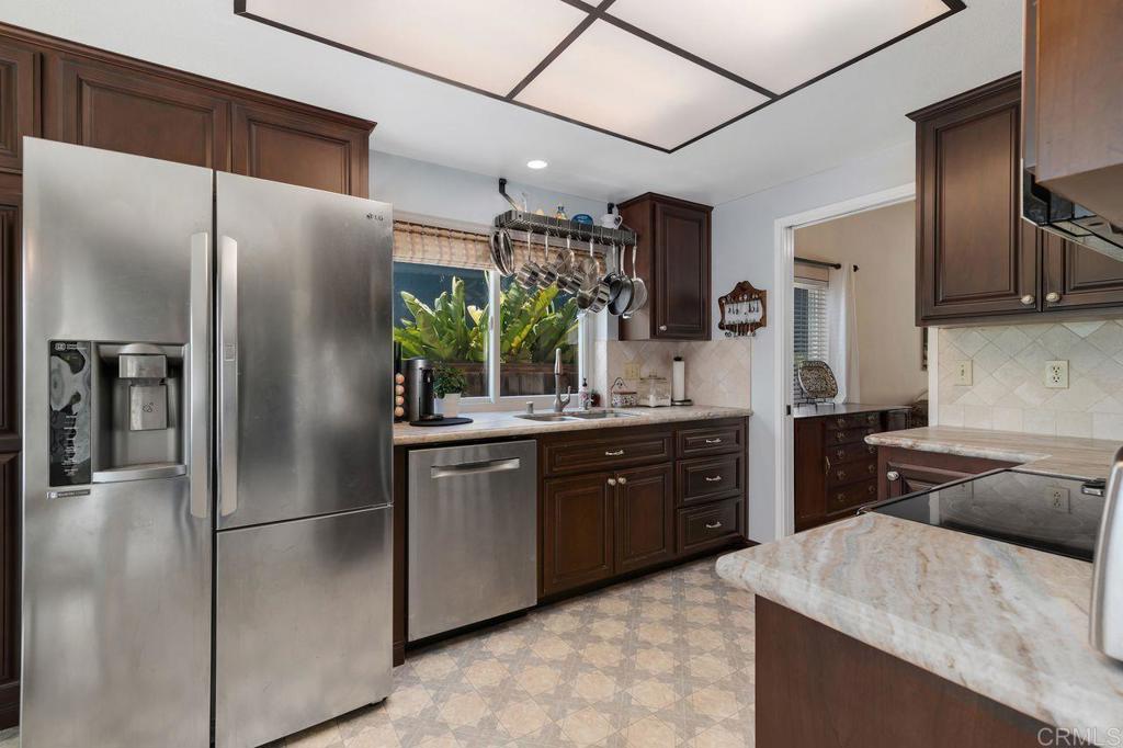 1064 Glen Arbor Drive Encinitas, CA 92024 - Photo 9 of 39 a kitchen with stainless steel appliances granite countertop a refrigerator a sink a stove and oven