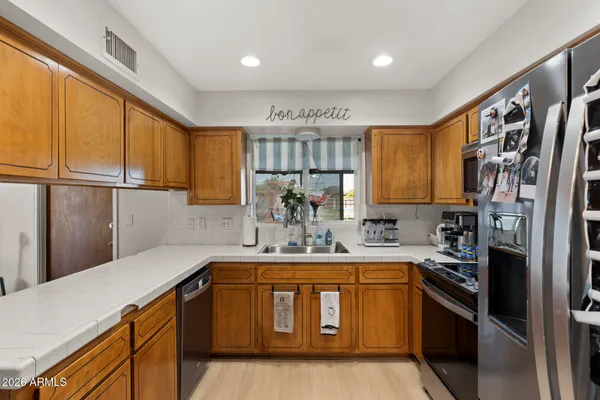 a kitchen with stainless steel appliances a sink stove and refrigerator