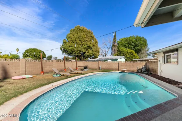 a swimming pool with outdoor seating and yard