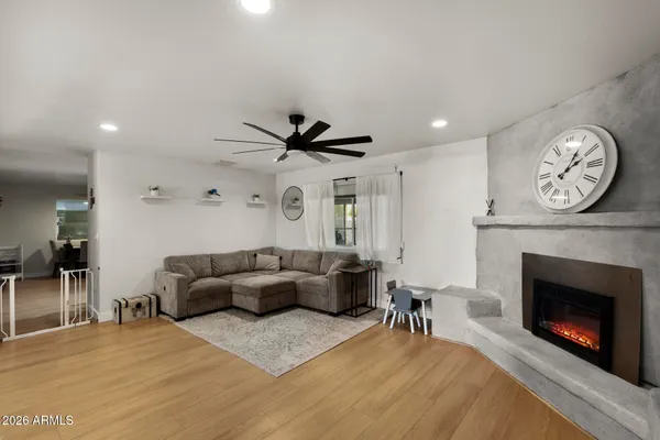 a living room with furniture a fireplace and a ceiling fan