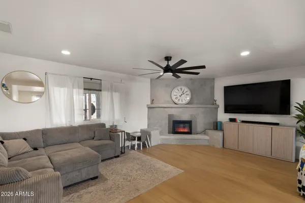 a living room with furniture a flat screen tv and a fireplace