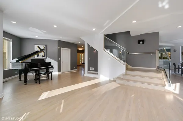 a living room with wooden floor and a piano