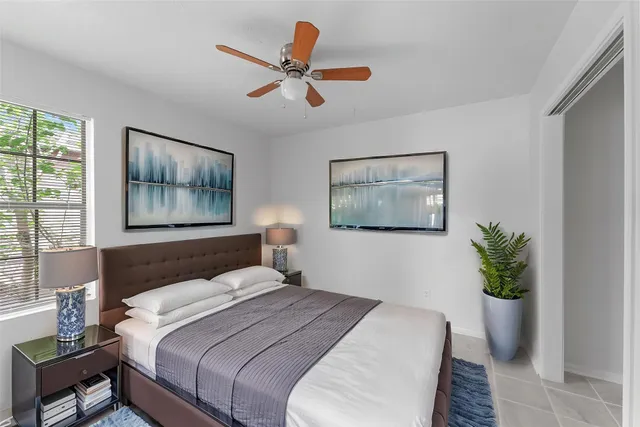 a bedroom with a large bed and a potted plant