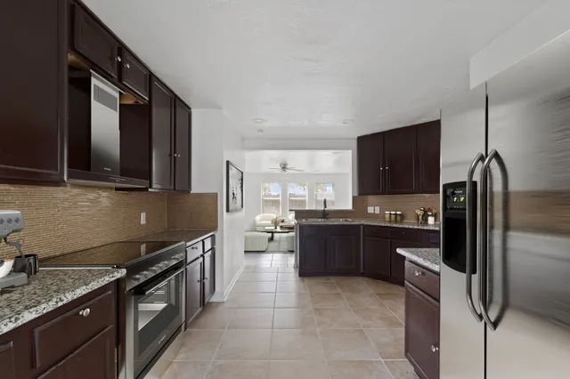 a kitchen with stainless steel appliances granite countertop a sink stove and refrigerator