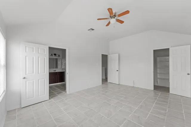 an empty room with closet and ceiling fan