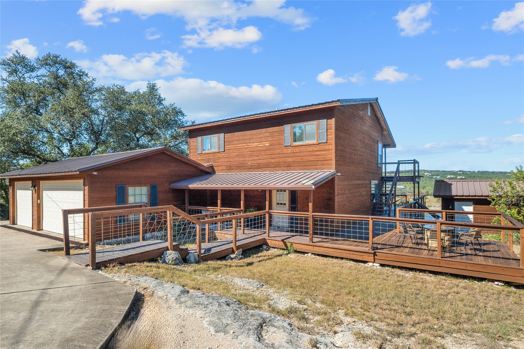 19645 Lakehurst Loop Spicewood, TX 78669 - Photo 13 of 40 Rustic lake home with a garage, a metal roof, and a deck