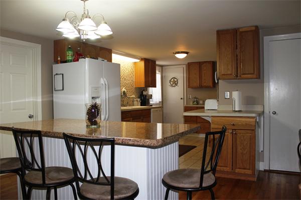 29 Cogger Road Lowell, MA 01854 - Photo 3 of 24 a kitchen with stainless steel appliances granite countertop a dining table chairs and a refrigerator