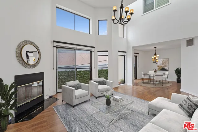 a living room with furniture a fireplace and a chandelier